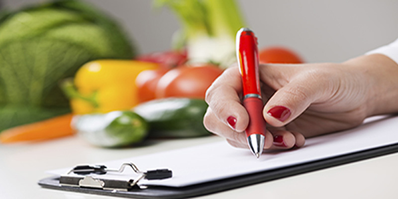 Image of hand holding pen on clipboard